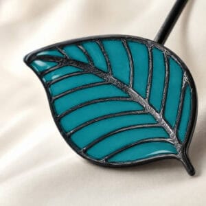 Macro view of the teal stained-glass resin leaf with raised veins