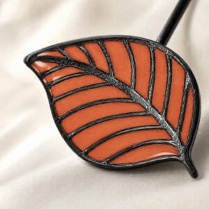 Macro view of the terracotta stained-glass resin leaf with raised veins