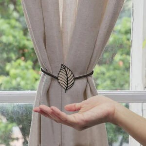leaf tieback on curtain with woman hand