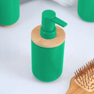 Green bamboo soap dispenser close up on white surface