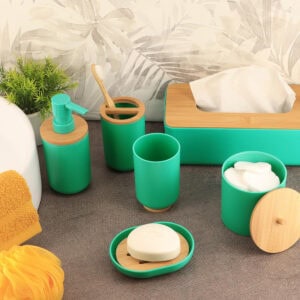 Green bathroom accessories set with bamboo accents on counter
