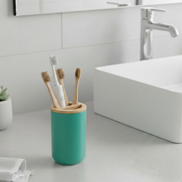 Green toothbrush holder with bamboo lid on modern bathroom sink