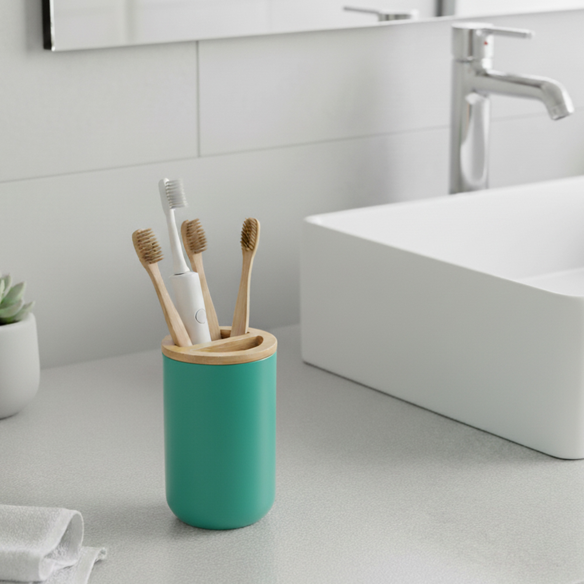 Green toothbrush holder with bamboo lid on modern bathroom sink