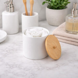 White cotton pad and Q-tip holder with bamboo lid on bathroom counter