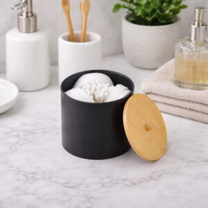 Black cotton pad and Q-tip holder with bamboo lid on bathroom counter
