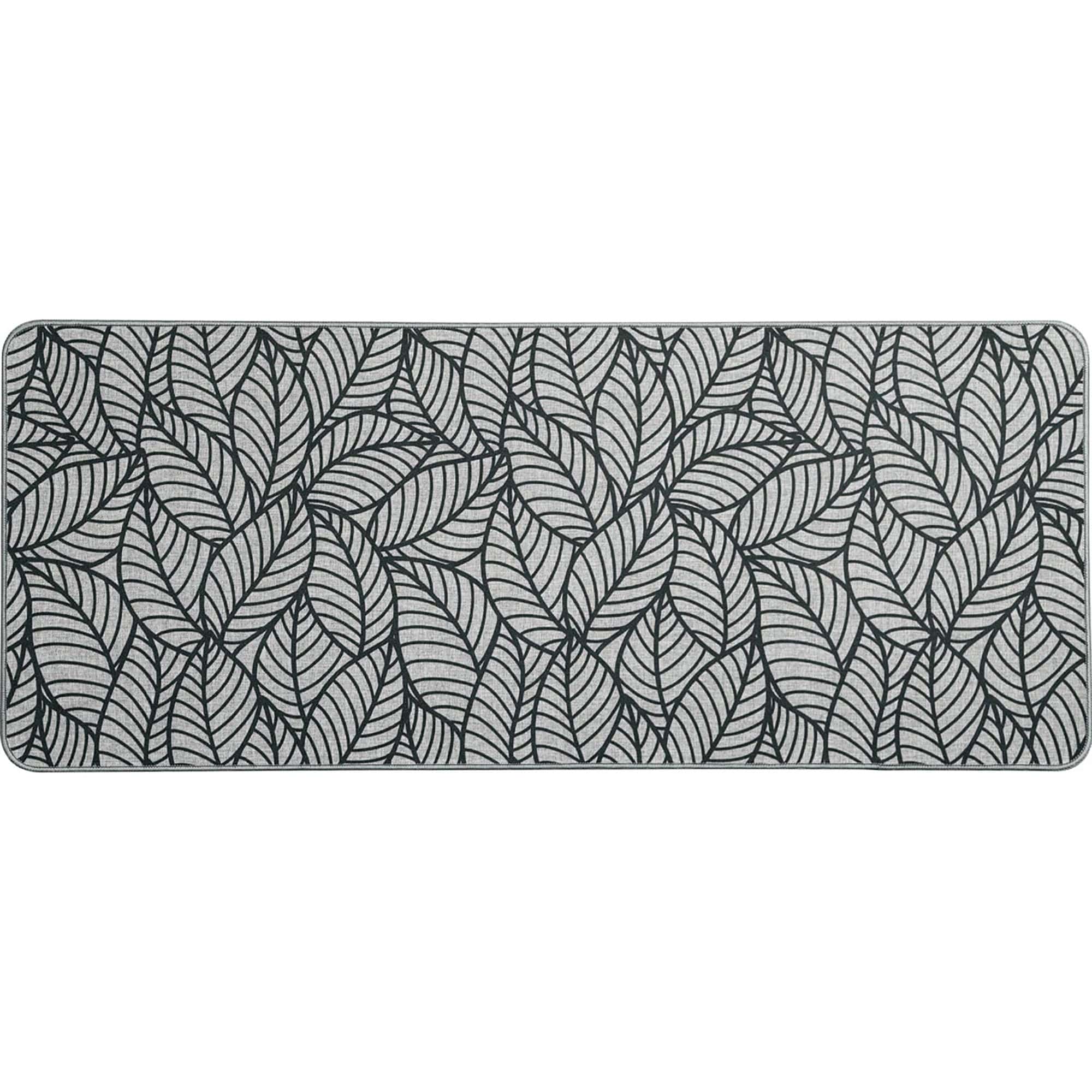 Grey kitchen runner with black leaf pattern lying flat, showing the long narrow shape, woven surface and stitched grey border.