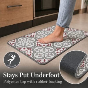 A bare foot resting on the standard kitchen mat near wood cabinets, with one corner flipped up to reveal the textured rubber anti-slip backing.