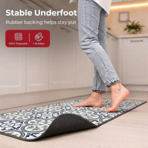 A bare foot steps onto the kitchen runner with one corner curled up to reveal the gray rubber backing, labeled one hundred percent polyester with rubber.