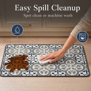 A hand wipes a brown spill from the kitchen mat with a white cloth, with icons showing the mat is spot clean and machine washable.