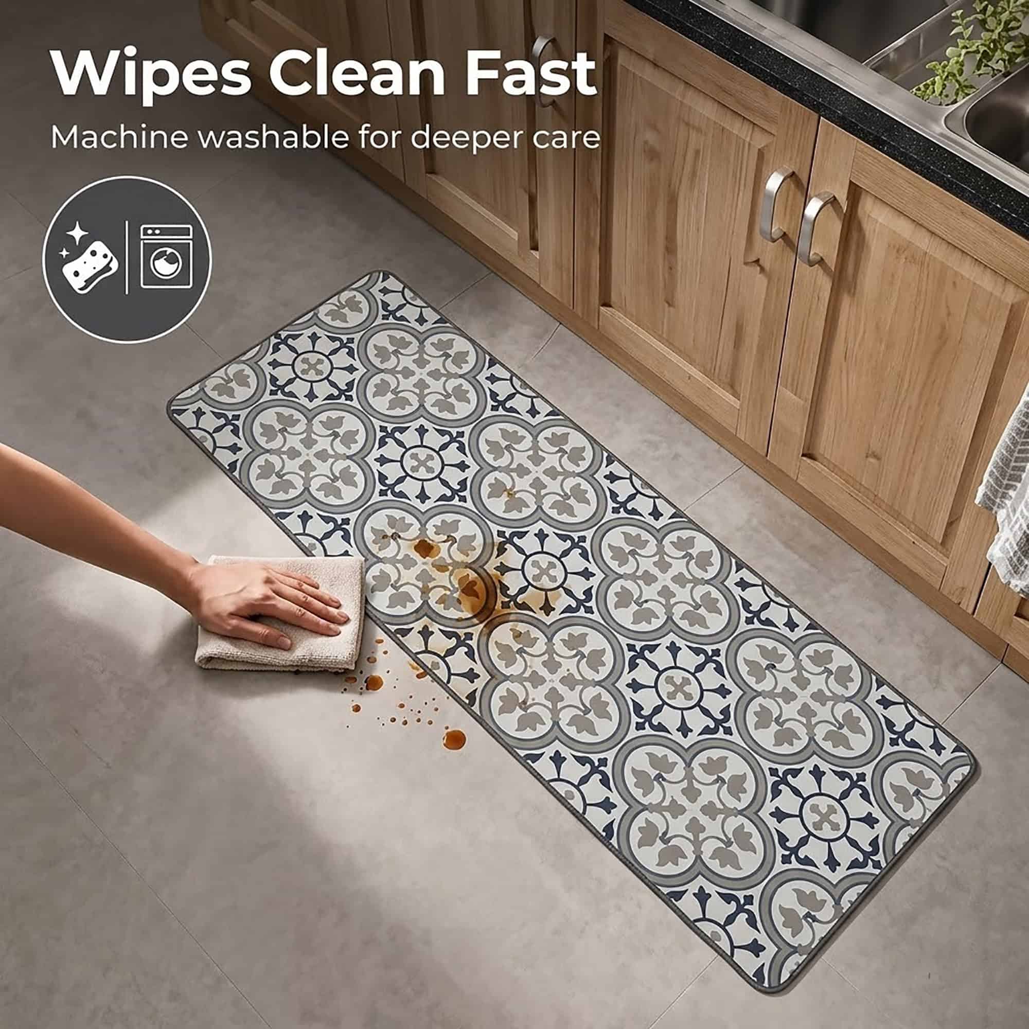 A hand wipes a brown spill from the long kitchen runner with a cloth, showing how the machine washable mat cleans up quickly.