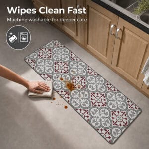 A hand wipes a brown spill from the long kitchen runner with a cloth, showing how the machine washable mat cleans up quickly.