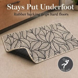Beige kitchen mat lifted at one corner to reveal the textured rubber backing that grips hard floors and prevents slipping underfoot.