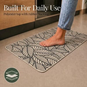 Beige leaf-print kitchen mat set showing the polyester top and rubber backing layers, built to withstand daily kitchen use.
