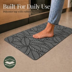 Grey leaf-print kitchen mat set showing the polyester top and rubber backing layers, built to withstand daily kitchen use.