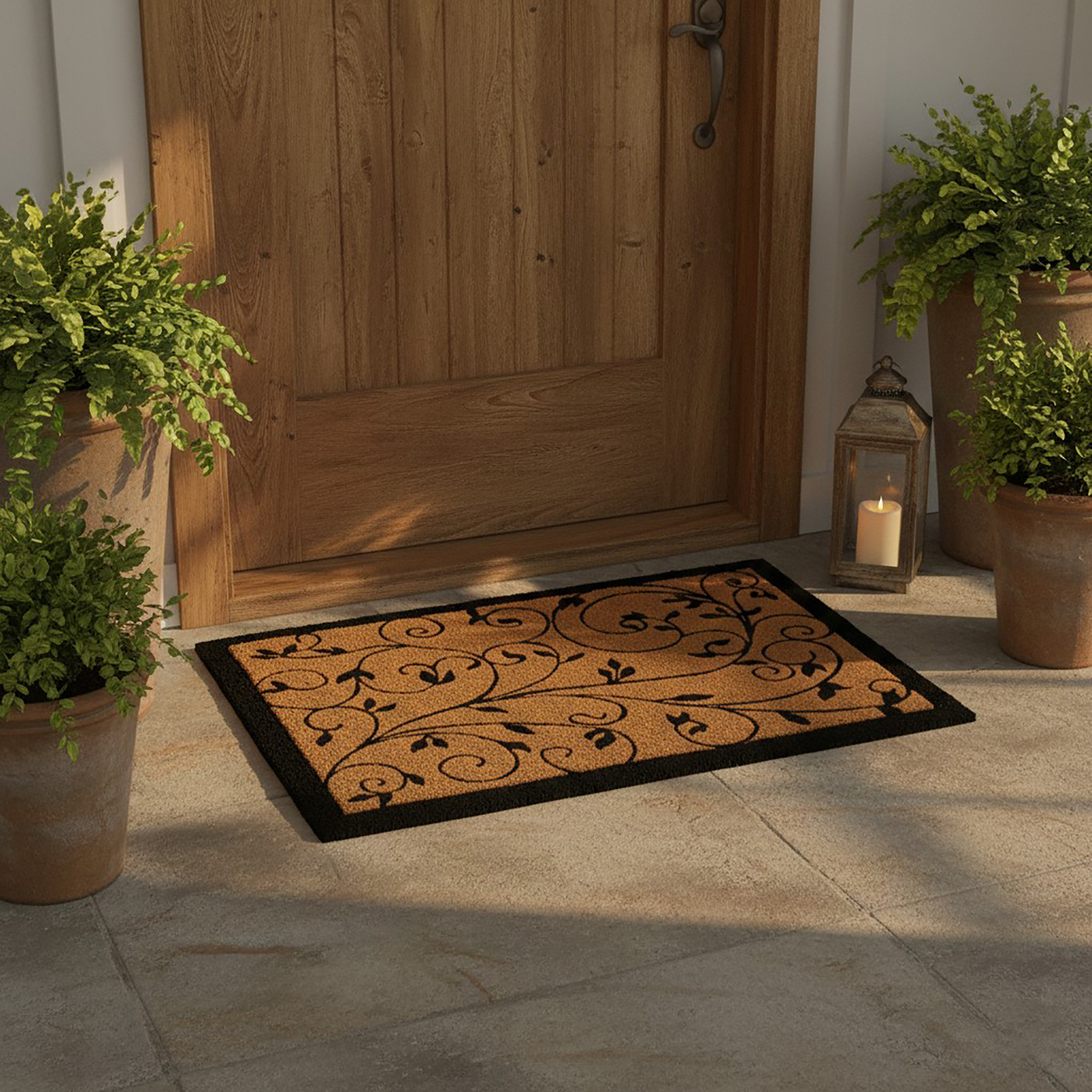 Leafy vine coir doormat placed at wooden front door with plants and lantern