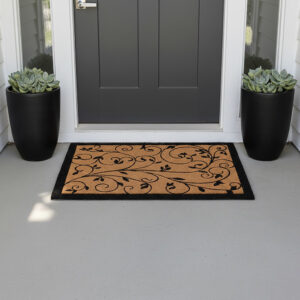 Leafy vine natural coir doormat at dark entry door with black planters