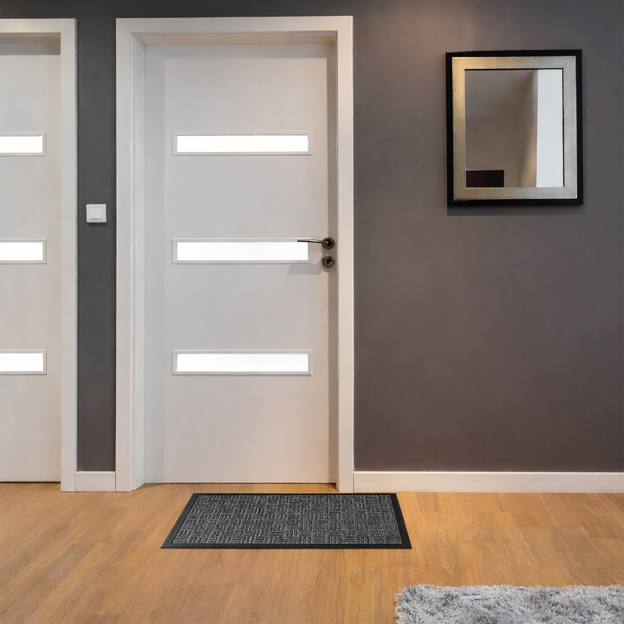 Gray low profile doormat placed in modern indoor entryway