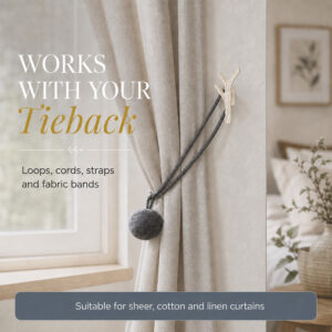 Branch tieback hook holding a curtain with a cord and pompom tieback on sheer linen drapes