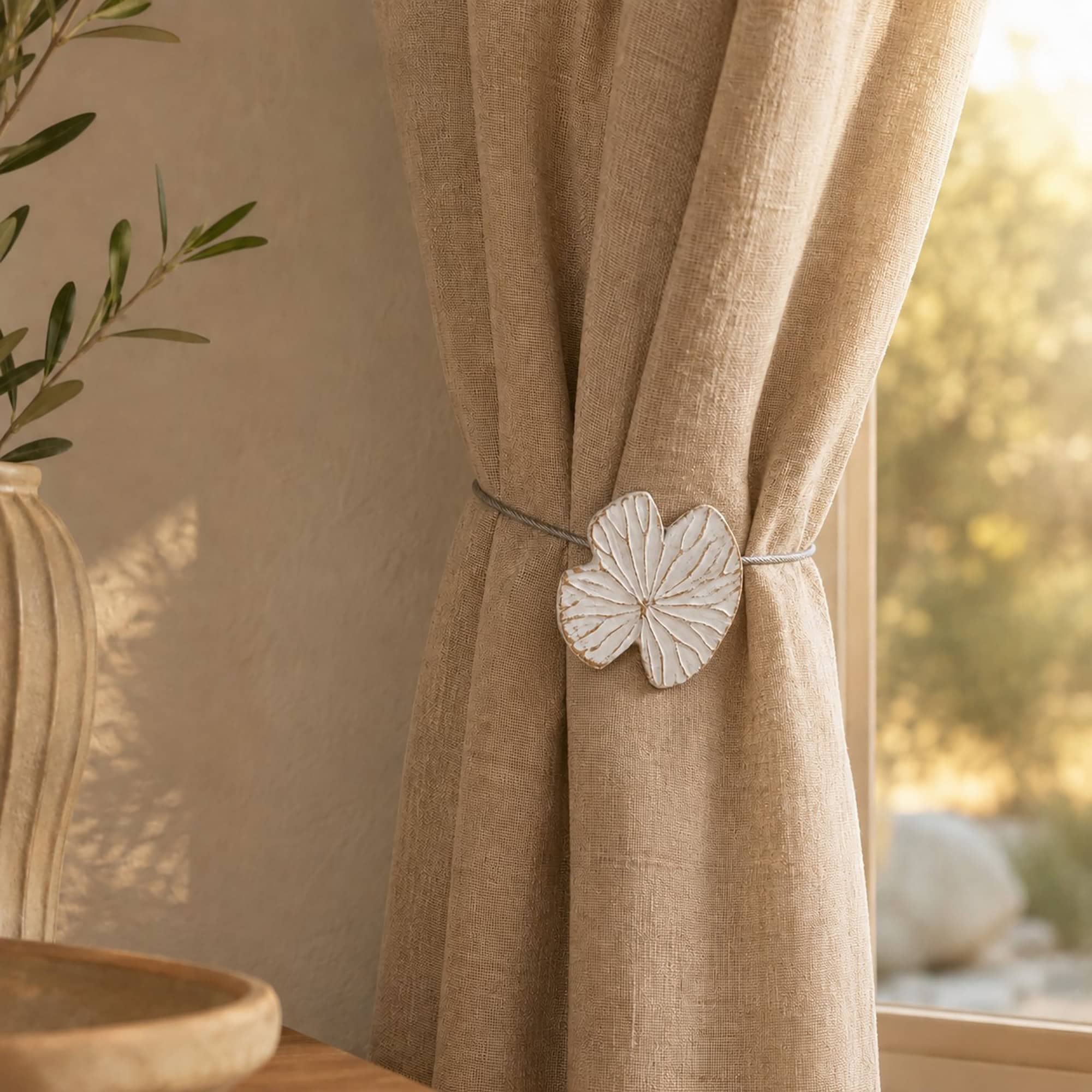 Lifestyle beige chaud: White water lily curtain tieback on a warm beige linen curtain in a cozy sunlit room