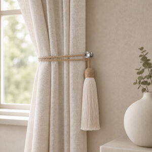 Chrome round holdback gathering neutral linen drapes with a rope tassel tieback in a living room
