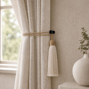 Black round holdback gathering neutral linen drapes with a rope tassel tieback in a living room
