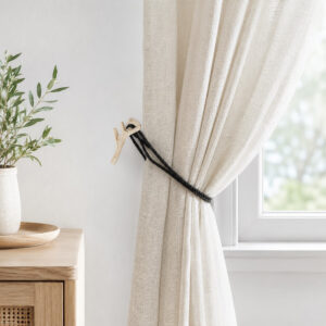 Ecru and gold branch holdback gathering a linen curtain by a window in a neutral living room