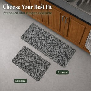 Two grey leaf-print kitchen mats shown together on a kitchen floor, a standard size beside a longer runner, near wood cabinets.