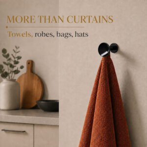 Black round wall hooks holding towels and robes in a bathroom, beyond curtain use