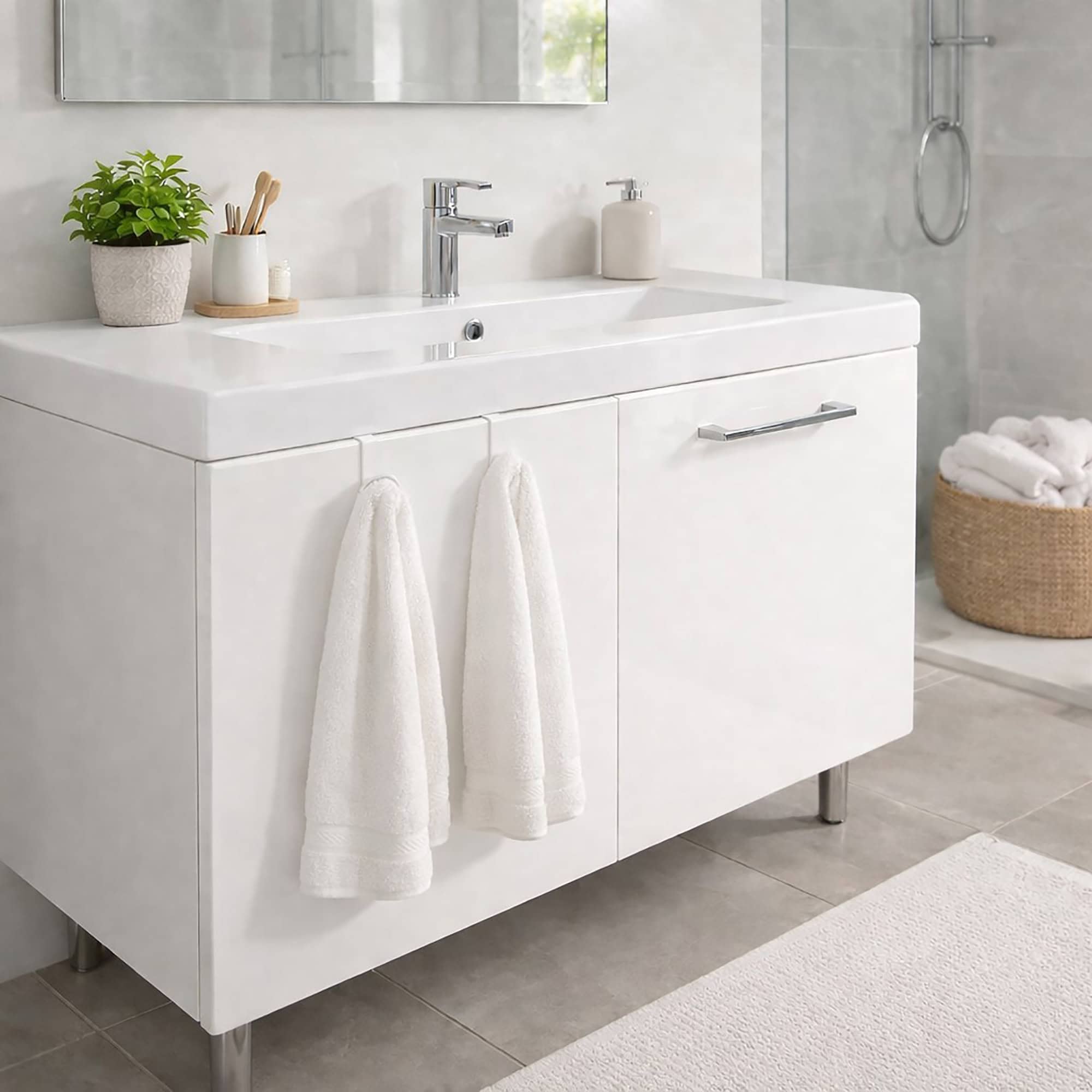 "Two white over-cabinet hooks holding white towels on white bathroom vanity cabinet"