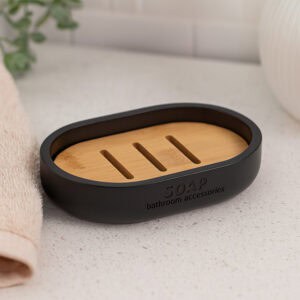 Black soap dish with bamboo insert on light stone countertop
