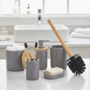 Gray bathroom accessory set with bamboo lids and accents displayed on countertop