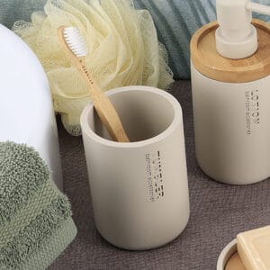 Toothbrush holder in a beige finish with bamboo accents in the background