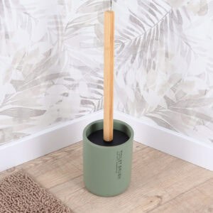 Green toilet brush and holder displayed on bathroom floor with botanical wallpaper backdrop