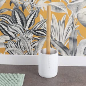 White toilet brush and holder displayed on bathroom floor with botanical wallpaper backdrop