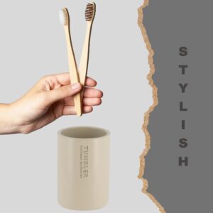 Close-up of a beige tumbler paired with bamboo toothbrushes