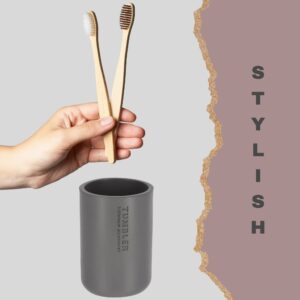 Gray toothbrush holder with bamboo brushes in modern bathroom