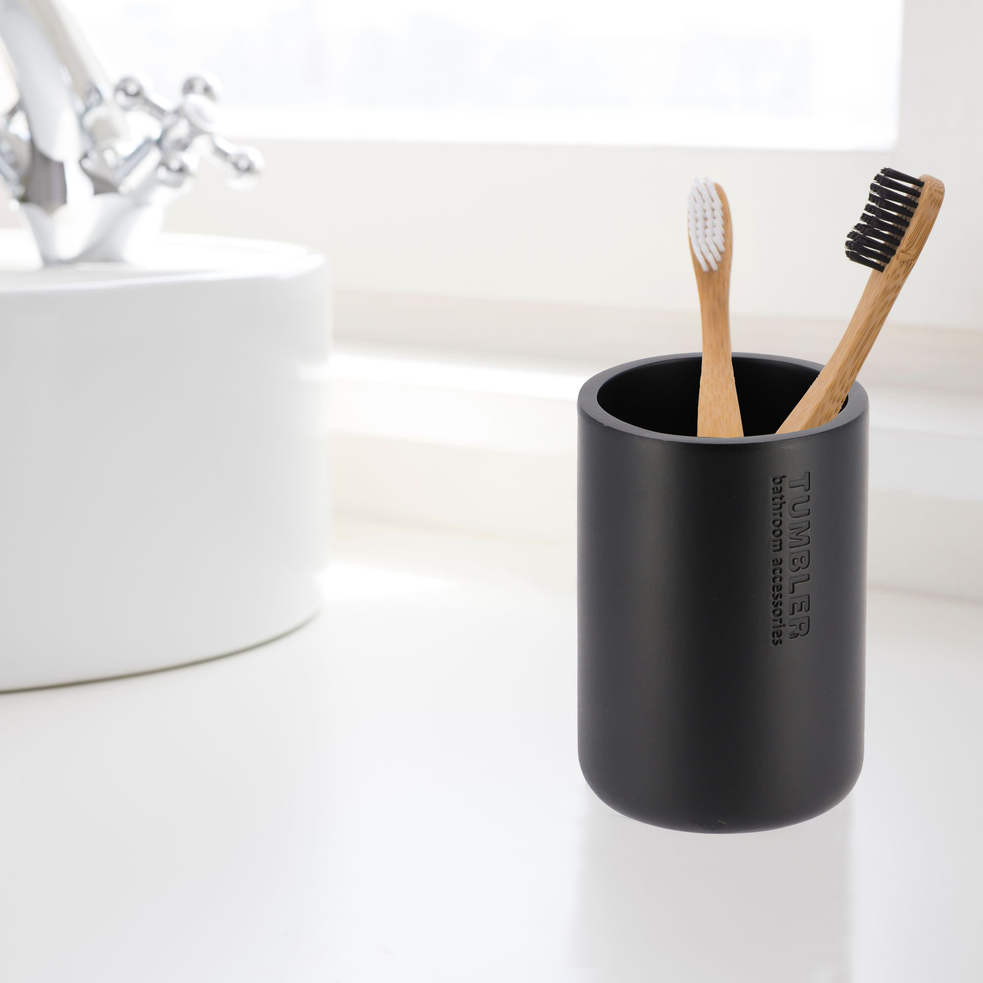 Modern black bathroom tumbler used as toothbrush holder on vanity