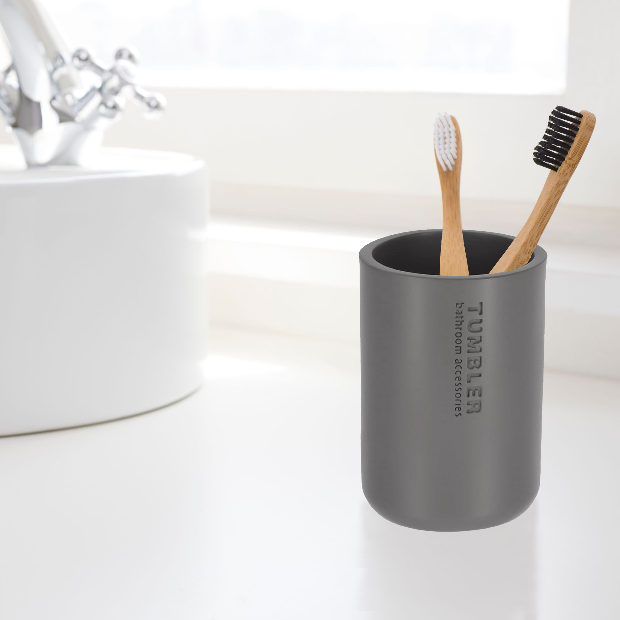 Modern gray bathroom tumbler used as toothbrush holder on vanity