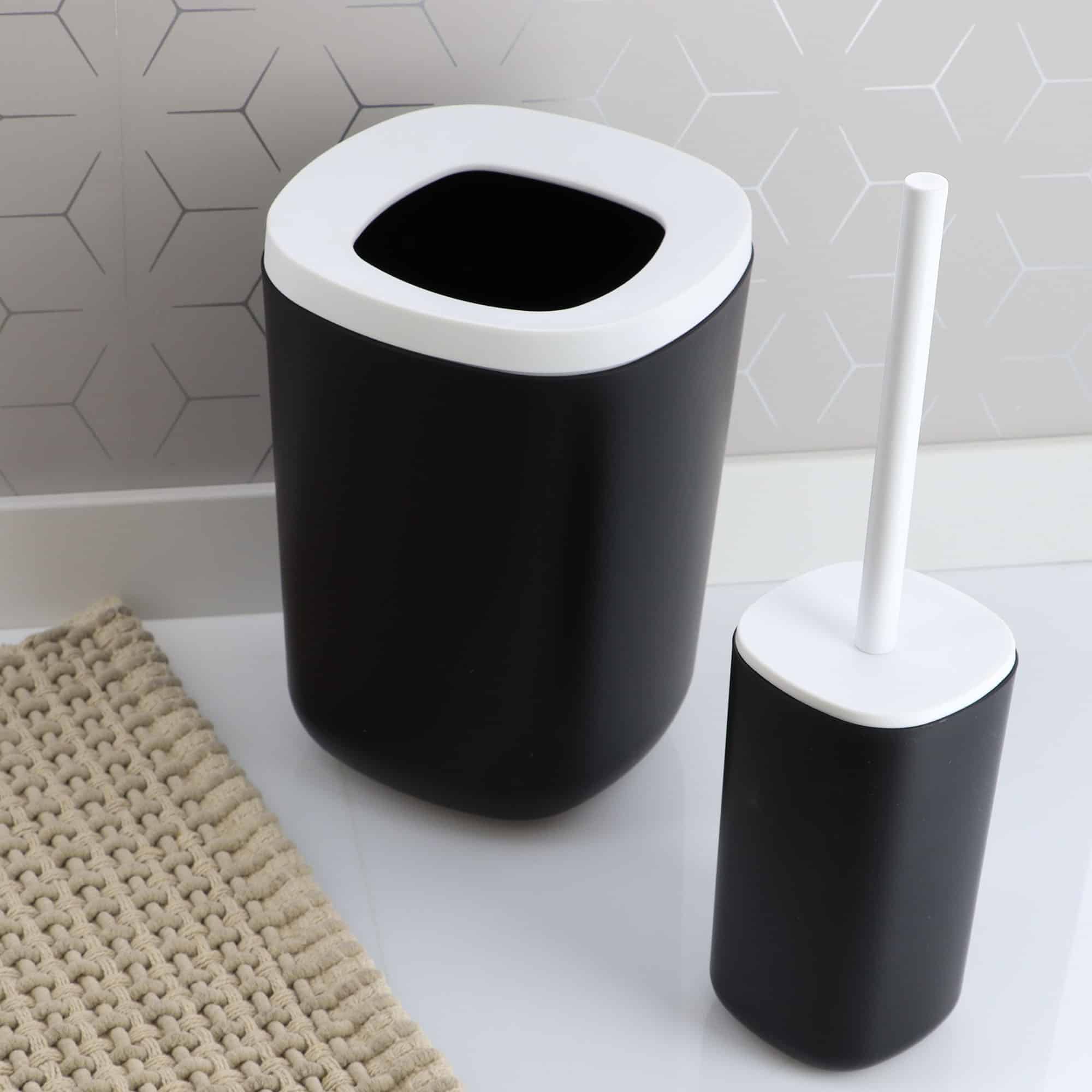 Black trash can and toilet brush set on bathroom floor