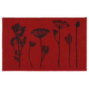 Red floral kitchen mat with black botanical stem print of wildflowers and seed heads displayed flat against a deep red background.