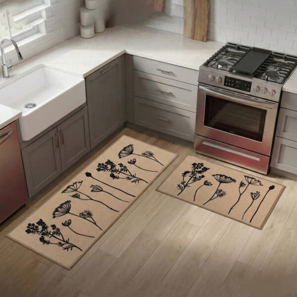 Natural beige floral mat and runner set on hardwood beside a farmhouse sink and stove, black botanical stems warming a bright modern kitchen.