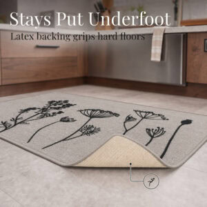 The gray floral rug is lifted at one corner to reveal the natural latex backing that grips hard floors and helps prevent slips underfoot.