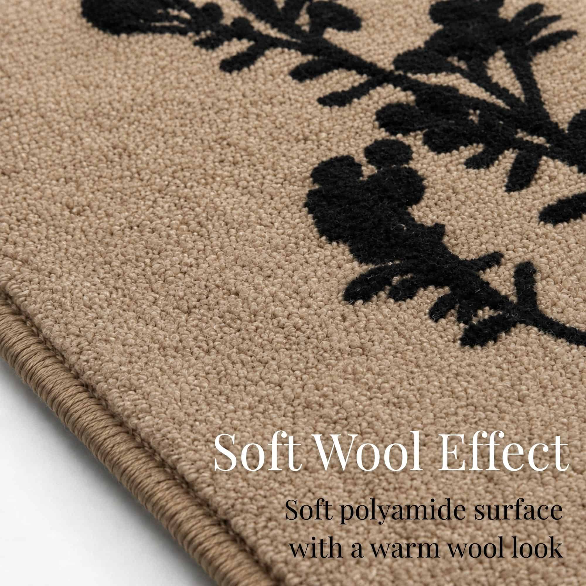 Close up of the natural beige kitchen rug surface showing soft textured polyamide pile and the crisp black botanical print with a warm wool look.