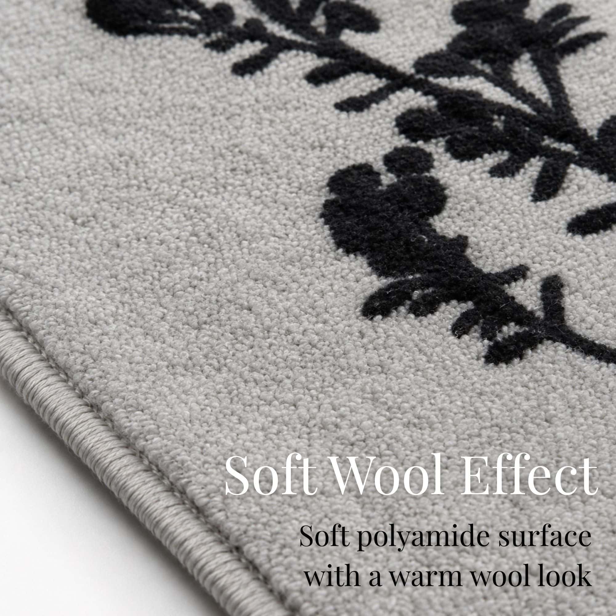 Close up of the gray kitchen runner surface showing soft textured polyamide pile and the crisp black botanical print with a warm wool look.