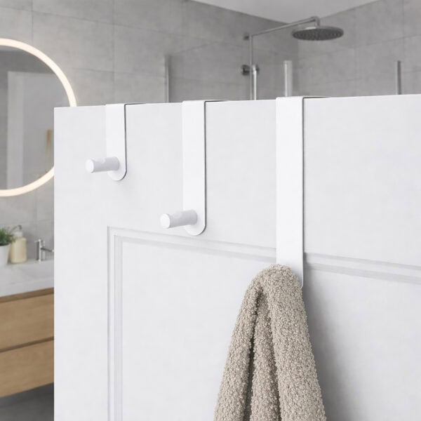 "Three white over-door hooks on white paneled bathroom door with beige towel hanging from lowest hook"
