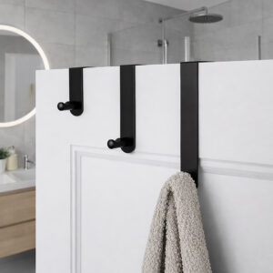"Three matte black over-door hooks on white paneled bathroom door with beige towel on lowest hook"