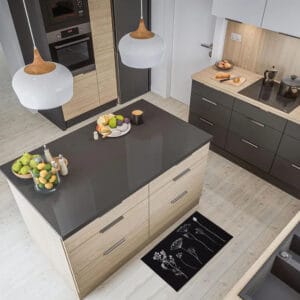 a modern kitchen with a central island and a black kitchen rug with botanical motifs