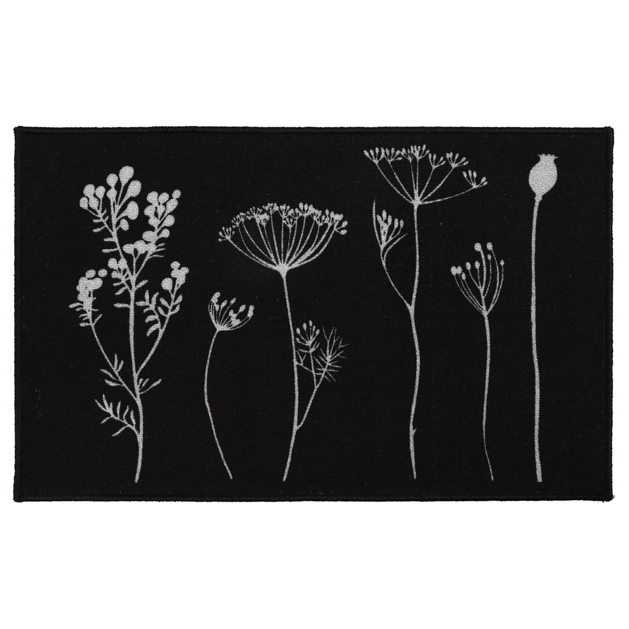 a black kitchen mat with a gray wildflowers motif