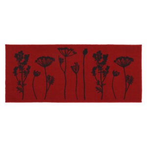a red kitchen runner mat with a black wildflowers motif