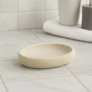 Beige sponge style round soap dish on tiled bathroom floor